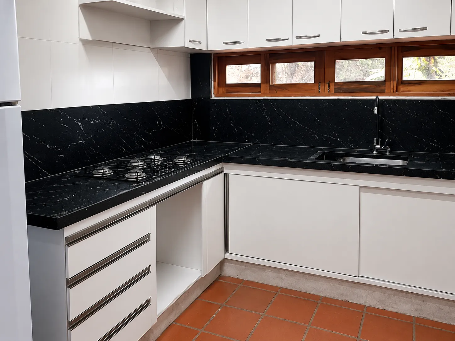 Cozinha em L com bancada e frontão de parede em granito Preto Via Láctea pontilhado